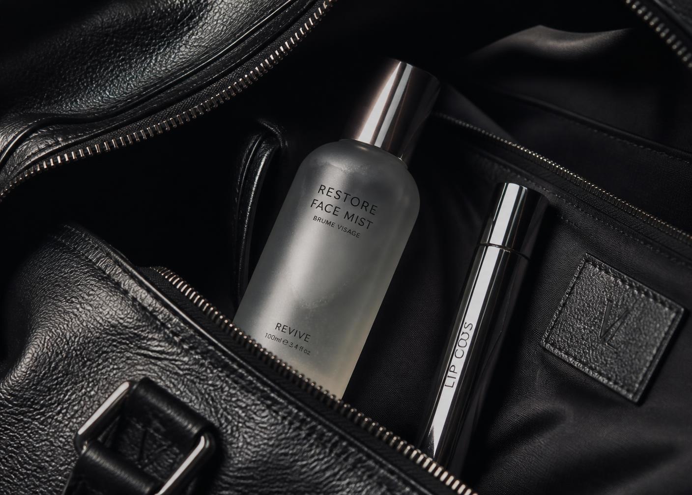 Aerial mist and lip gloss tucked inside a black gym bag